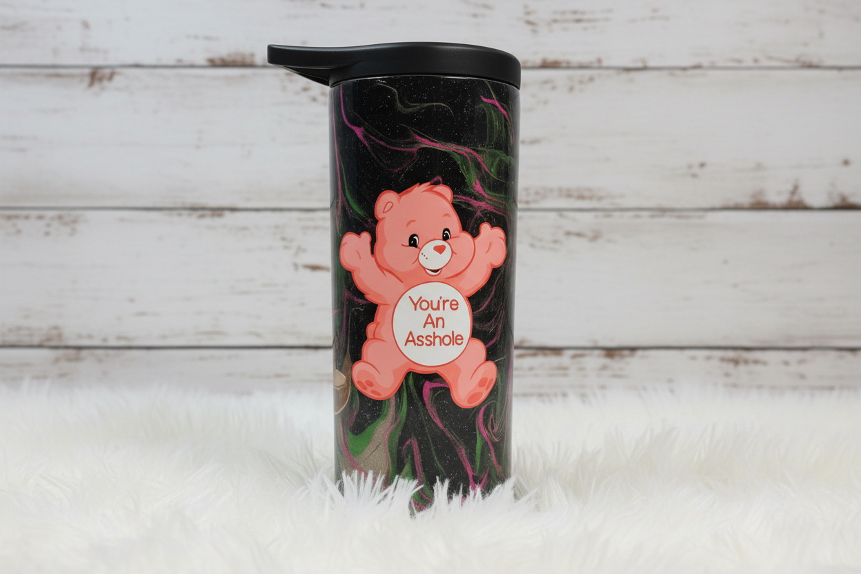Tumbler with a pink bear character and text on a black marbled background